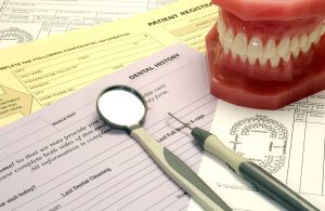 Dental model and tools on top of patient forms.